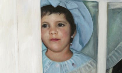 A child girl looking from behind a glass door