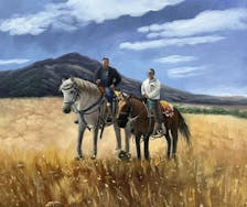 Two horseback riders in a field